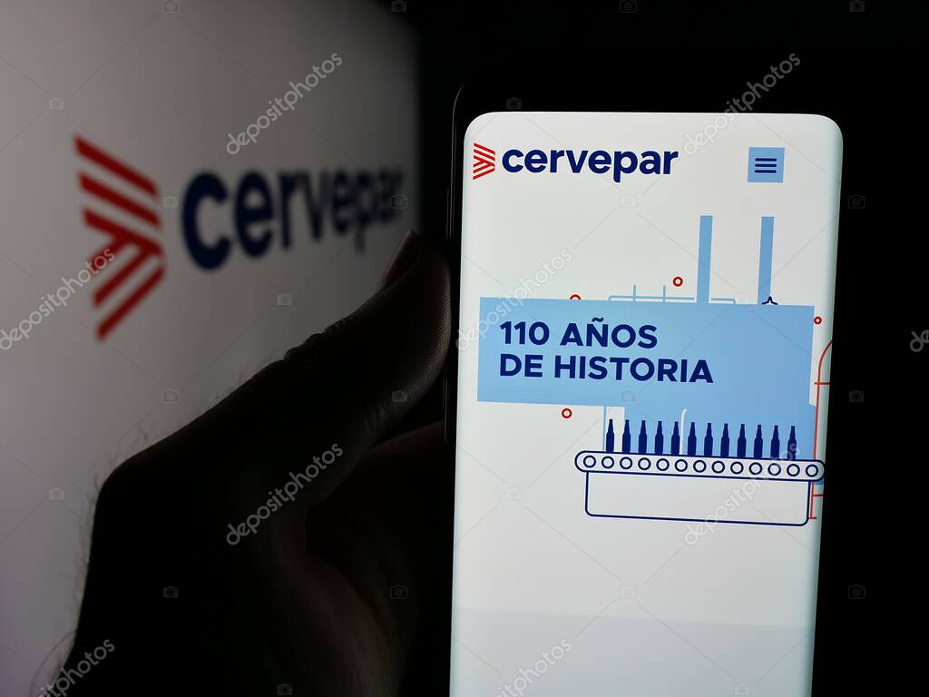 Stuttgart, Germany - 05-03-2025: Person holding smartphone with website of company Cerveceria Paraguaya S.A. (Cervepar) on screen in front of logo. Focus on center of phone display.