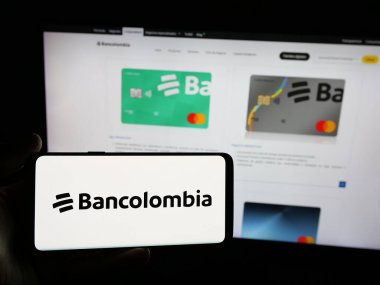 Stuttgart, Almanya - 05-04-2025: Kolombiyalı finans şirketi Bancolombia S.A. 'nın logosunu elinde tutan kişi web sitesinin önünde ekranda. Telefon ekranına odaklan.