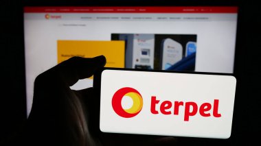 Stuttgart, Almanya - 05-04-2025: İnternet sayfası önünde üzerinde petrol şirketi Organizacion Terpel S.A. logosu bulunan cep telefonu sahibi kişi. Telefon ekranına odaklan.