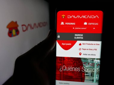 Stuttgart, Almanya - 05-04-2025: Finans şirketi Banco Davivienda S.A. 'nın internet sitesi ile akıllı telefon sahibi kişi logo önünde ekranda. Telefon ekranının merkezine odaklan.