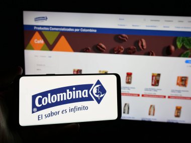Stuttgart, Almanya - 05-04-2025: İnternet sitesinin önünde ekranda gıda işleme şirketi Colombina S.A. 'nın logosuna sahip akıllı telefonu tutan kişi. Telefon ekranına odaklan.