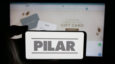 Stuttgart, Almanya - 05-04-2025: Paraguay şirketi Manufactura de Pilar S.A. 'nın logosunun bulunduğu cep telefonu web sayfası önünde ekranda. Telefon ekranına odaklan.