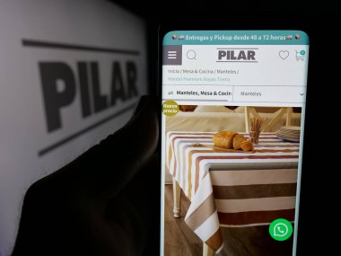 Stuttgart, Almanya - 05-04-2025: Paraguay şirketi Manufactura de Pilar S.A. 'nın web sitesi ile akıllı telefon sahibi kişi logonun önünde ekranda. Telefon ekranının merkezine odaklan.