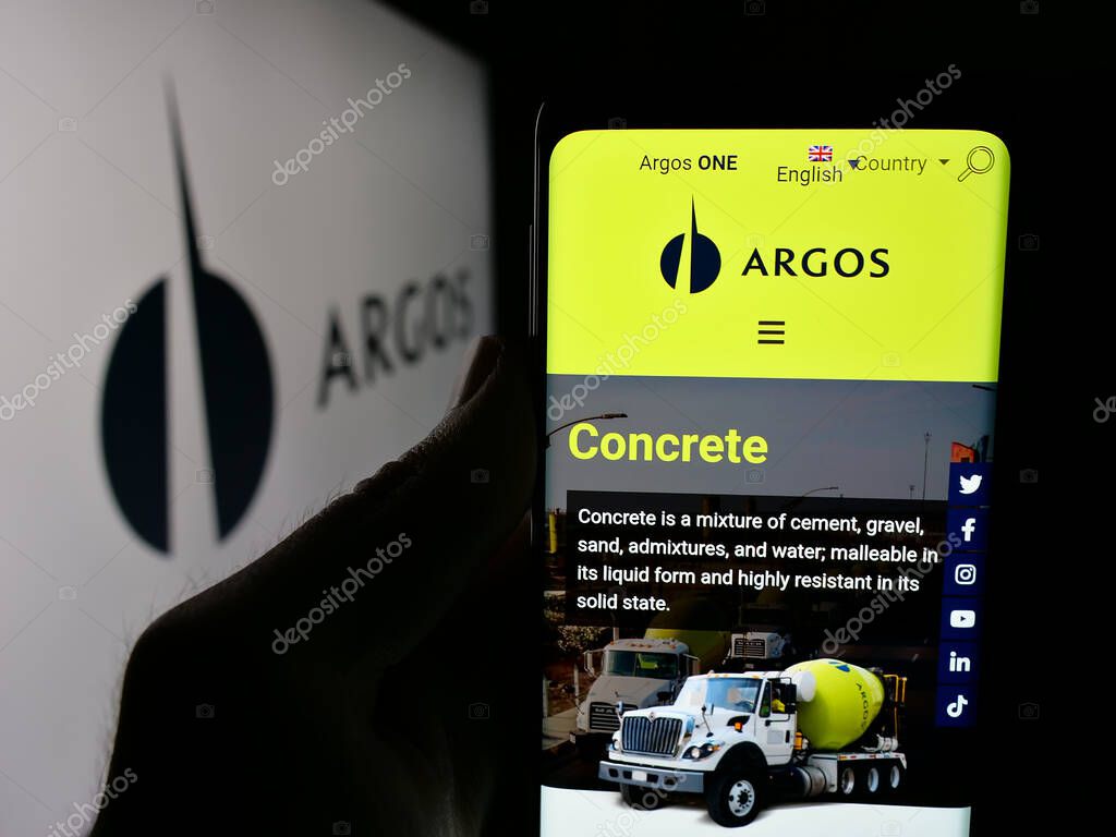Stuttgart, Germany - 05-04-2025: Person holding cellphone with web page of building materials company Grupo Argos S.A. on screen in front of logo. Focus on center of phone display.