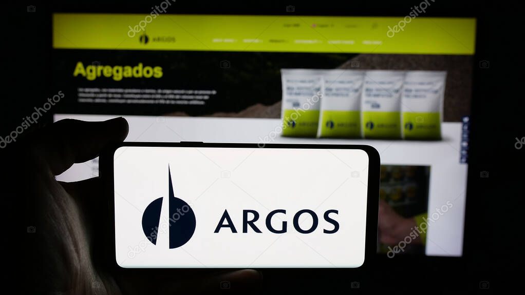 Stuttgart, Germany - 05-04-2025: Person holding cellphone with logo of building materials company Grupo Argos S.A. on screen in front of webpage. Focus on phone display.