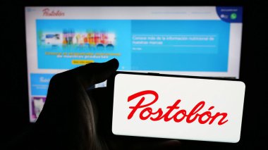 Stuttgart, Almanya - 05-05-2025: Cep telefonunda Kolombiyalı içecek şirketi Postobon S.A. 'nın logosu olan kişi web sayfasının önünde ekranda. Telefon ekranına odaklan.
