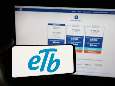 Stuttgart, Almanya - 05-05-2025: İnternet sitesinin önünde üzerinde Empresa de Telecomunicaciones de Bogota (ETB) logosu bulunan kişi. Telefon ekranına odaklan.