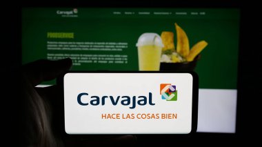 Stuttgart, Almanya - 05-05-2025: Cep telefonunda Kolombiyalı Carvajal S.A. şirketinin logosu olan kişi web sayfasının önünde ekranda. Telefon ekranına odaklan.