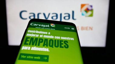 Stuttgart, Almanya - 05-05-2025: Sitenin önünde ekranda Kolombiyalı Carvajal S.A. şirketinin logosunun olduğu cep telefonu. Telefon ekranının sol üst kısmına odaklan.