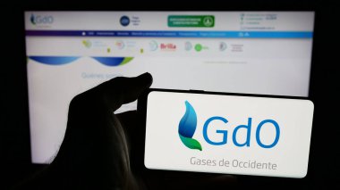 Stuttgart, Almanya - 05-05-2025: İnternet sayfasının önünde ekranda Gases de Occidente S.A. logosu olan cep telefonu sahibi kişi. Telefon ekranına odaklan.