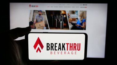 Stuttgart, Almanya - 05-06-2025: ABD 'li Breakthru Beverage Group LLC logosunun bulunduğu cep telefonu web sayfası önünde ekranda. Telefon ekranına odaklan.