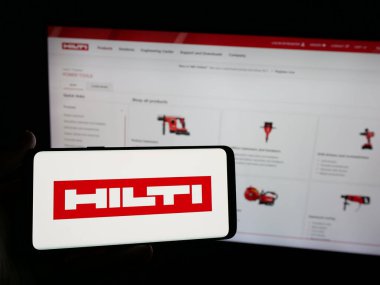 Stuttgart, Almanya - 05-06-2025: İnternet sitesinin önünde üzerinde elektrikli alet şirketi Hilti AG logosu bulunan akıllı telefon sahibi kişi. Telefon ekranına odaklan.