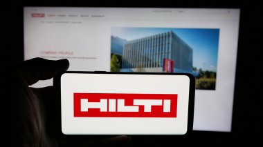 Stuttgart, Almanya - 05-06-2025: İnternet sayfası önünde ekranda Hilti AG adlı elektrikli alet şirketinin logosuna sahip cep telefonu bulunduran kişi. Telefon ekranına odaklan.