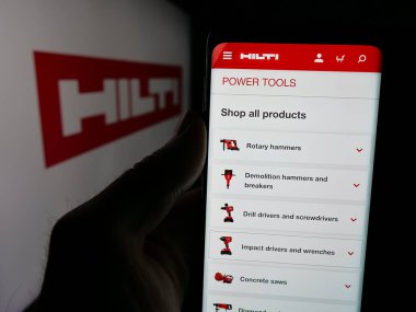 Stuttgart, Almanya - 05-06-2025: Logo önünde ekranda Hilti AG adlı elektrikli alet şirketinin web sayfası ile cep telefonu tutan kişi. Telefon ekranının merkezine odaklan.