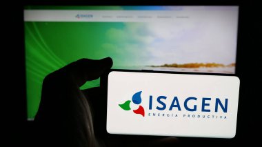 Stuttgart, Almanya - 05-06-2025: Kolombiyalı enerji şirketi Isagen S.A. E.S.P. 'nin logosuna sahip cep telefonu sahibi kişi Web sayfasının önünde ekranda. Telefon ekranına odaklan.