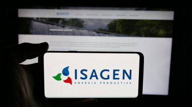 Stuttgart, Almanya - 05-06-2025: Kolombiyalı enerji şirketi Isagen S.A. E.S.P. 'nin logosuyla cep telefonu tutan kişi Web sayfasının önünde ekranda. Telefon ekranına odaklan.