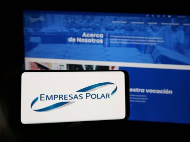 Stuttgart, Almanya - 05-06-2025: Venezüellalı içecek şirketi Empresas Polar 'ın logosunu elinde tutan kişi web sitesinin önünde ekranda. Telefon ekranına odaklan.