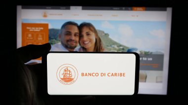 Stuttgart, Almanya - 05-06-2025: Finans hizmetleri şirketi Banco di Caribe 'nin logosunun bulunduğu cep telefonu web sayfası önünde ekranda. Telefon ekranına odaklan.