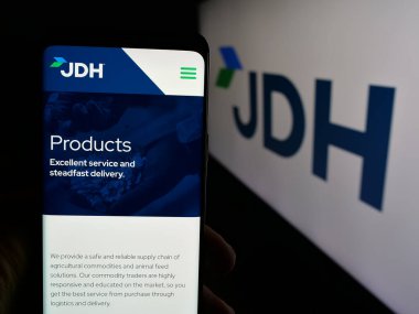 Stuttgart, Almanya - 05-07-2025: ABD 'li J.D. şirketinin web sayfası ile cep telefonu tutan kişi Heiskell Holding LLLC (JDH) logonun önünde ekranda. Telefon ekranının merkezine odaklan.