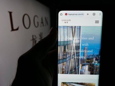 Stuttgart, Almanya - 05-07-2025: Çinli Logan Group Limited şirketinin logosunun bulunduğu web sayfası logonun önünde ekranda. Telefon ekranının merkezine odaklan.