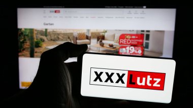 Stuttgart, Almanya - 05-07-2025: Avusturyalı mobilya şirketi XXXLutz KG 'nin logosuna sahip cep telefonu web sayfası önünde ekranda. Telefon ekranına odaklan.