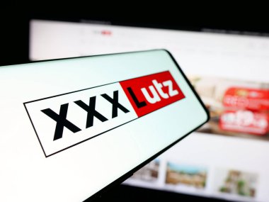 Stuttgart, Almanya - 05-07-2025: Avusturyalı mobilya şirketi XXXLutz KG 'nin logosuna sahip akıllı telefon web sitesinin önünde ekranda. Telefon ekranının soluna odaklan.