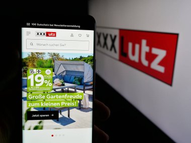 Stuttgart, Almanya - 05-07-2025: Avusturyalı mobilya şirketi XXXLutz KG 'nin web sayfası olan cep telefonu logonun önünde ekranda. Telefon ekranının merkezine odaklan.