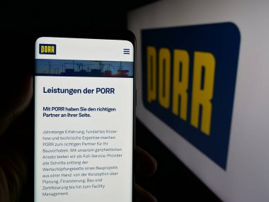 Stuttgart, Almanya - 05-07-2025: Avusturyalı inşaat şirketi Porr AG 'nin web sayfası olan cep telefonu logonun önünde ekranda. Telefon ekranının merkezine odaklan.