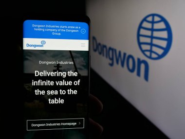 Stuttgart, Almanya - 05-07-2025: Koreli şirket Dongwon Industries Ltd. 'nin internet sayfası olan cep telefonu logonun önünde ekranda. Telefon ekranının merkezine odaklan.