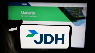 Stuttgart, Almanya - 05-07-2025: ABD 'li J.D. şirketinin logosuna sahip cep telefonu sahibi kişi Heiskell Holding LLLC (JDH) web sayfasının önünde ekranda. Telefon ekranına odaklan.