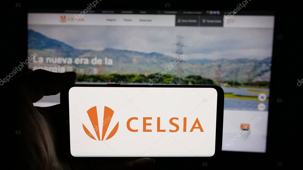 Stuttgart, Germany - 05-05-2025: Person holding cellphone with logo of Colombian energy company Celsia S.A. E.S.P. on screen in front of webpage. Focus on phone display.