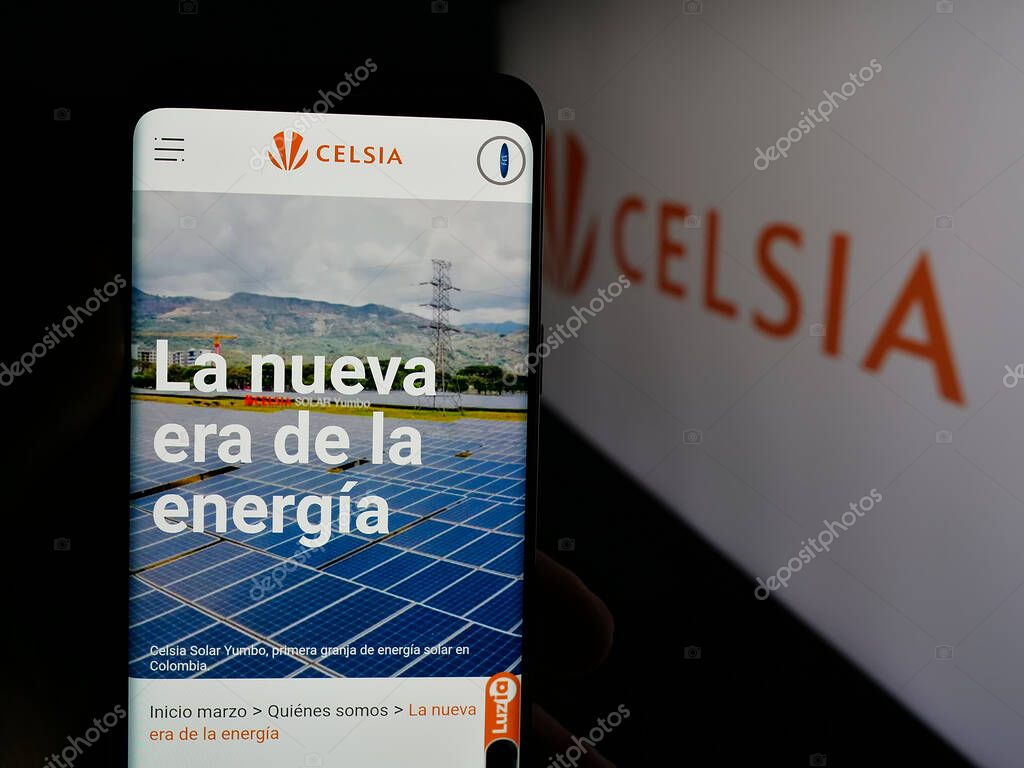 Stuttgart, Germany - 05-05-2025: Person holding cellphone with webpage of Colombian energy company Celsia S.A. E.S.P. on screen in front of logo. Focus on center of phone display.