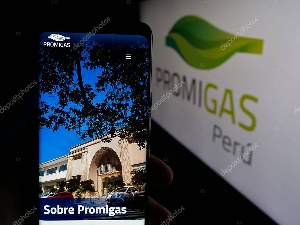 Stuttgart, Germany - 05-05-2025: Person holding web page with logo of Colombian energy company Promigas S.A. E.S.P. on screen in front of logo. Focus on center of phone display.