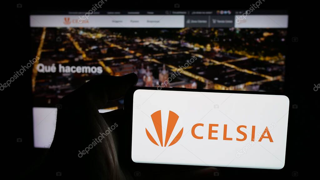 Stuttgart, Germany - 05-05-2025: Person holding mobile phone with logo of Colombian energy company Celsia S.A. E.S.P. on screen in front of web page. Focus on phone display.
