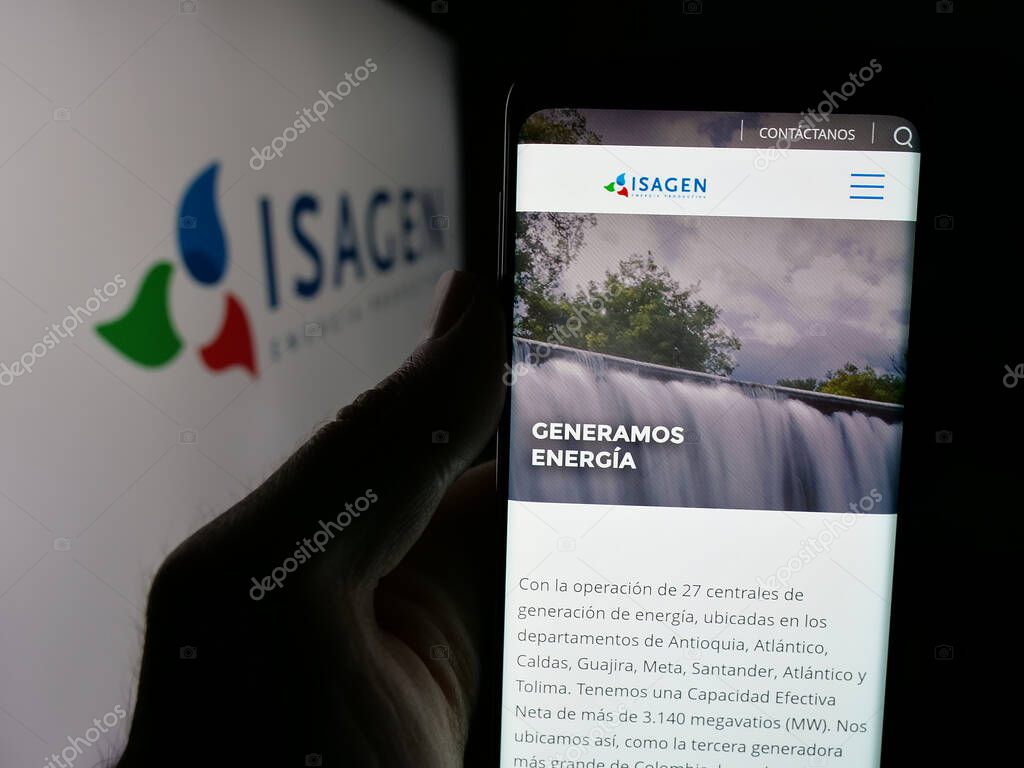 Stuttgart, Germany - 05-06-2025: Person holding web page with logo of Colombian energy company Isagen S.A. E.S.P. on screen in front of logo. Focus on center of phone display.