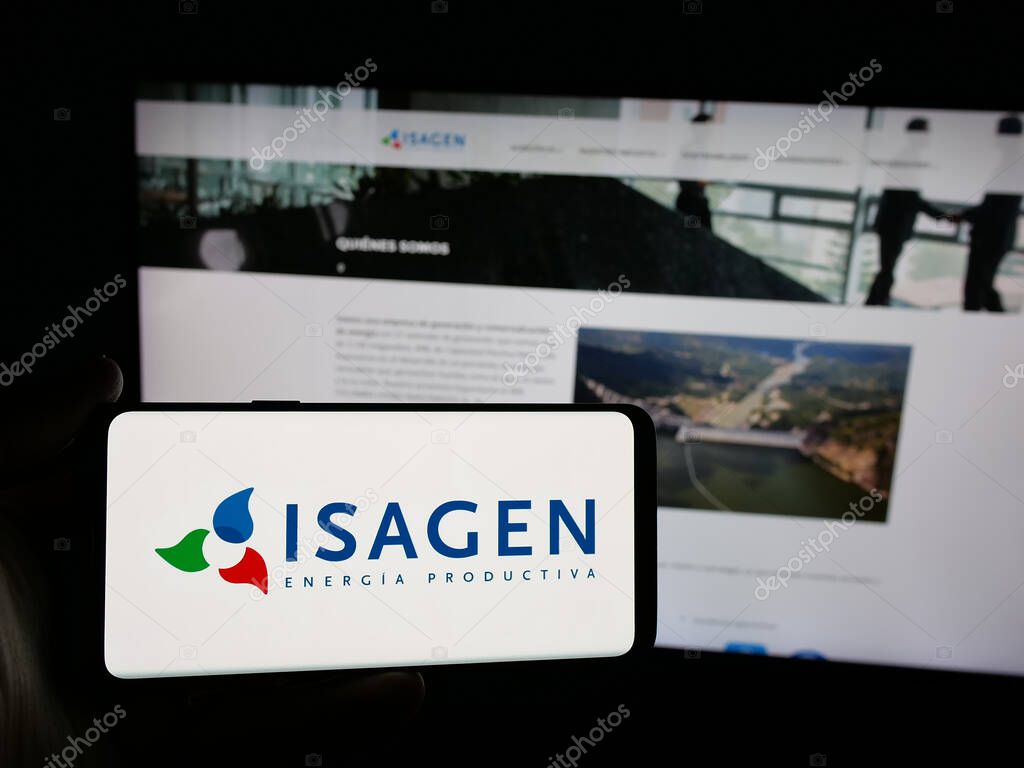 Stuttgart, Germany - 05-06-2025: Person holding smartphone with logo of Colombian energy company Isagen S.A. E.S.P. on screen in front of website. Focus on phone display.