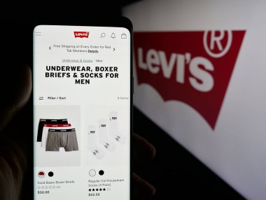 Stuttgart, Almanya - 05-14-2025: ABD 'li giyim şirketi Levi Strauss Co. (Levi' s) 'un internet sayfası olan cep telefonu logonun önünde ekranda. Telefon ekranının merkezine odaklan.