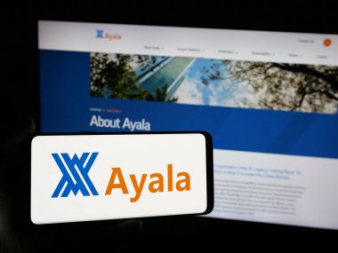 Stuttgart, Almanya - 05-14-2025: Filipinli holding şirketi Ayala Corporation 'ın logosunu elinde tutan kişi web sitesinin önünde ekranda. Telefon ekranına odaklan.