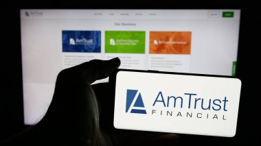 Stuttgart, Almanya - 05-15-2025: ABD 'li AmTrust Finansal Hizmetler Şirketi' nin logosunun bulunduğu cep telefonu web sayfası önünde ekranda. Telefon ekranına odaklan.