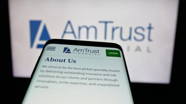 Stuttgart, Almanya - 05-15-2025: ABD 'li AmTrust Finansal Hizmetler Şirketi' nin web sitesiyle birlikte cep telefonu logonun önünde ekranda. Telefon ekranının sol üst kısmına odaklan.