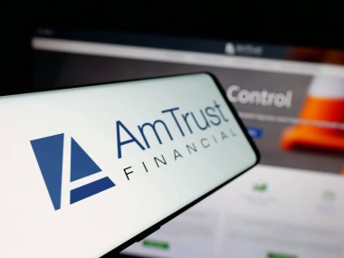 Stuttgart, Almanya - 05-15-2025: İnternet sitesi önünde ekranda AmTrust Finansal Hizmetler Şirketi logosu bulunan akıllı telefon. Telefon ekranının soluna odaklan.