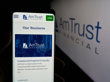 Stuttgart, Almanya - 05-15-2025: ABD 'li AmTrust Finansal Hizmetler Şirketi' nin internet sayfası olan cep telefonu logosu önünde ekranda. Telefon ekranının merkezine odaklan.