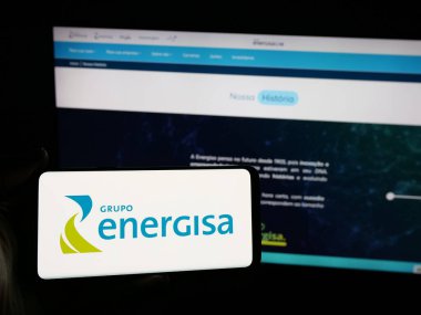 Stuttgart, Almanya - 05-15-2025: Brezilyalı enerji şirketi Energisa S.A. 'nın logosunu elinde tutan kişi web sitesinin önünde ekranda. Telefon ekranına odaklan.