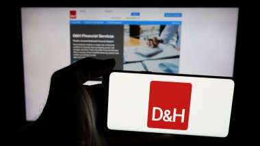 Stuttgart, Almanya - 05-15-2025: İnternet sayfasının önündeki ekranda IT dağıtım şirketi DH Distributing Co. 'nun logosuyla cep telefonu tutan kişi. Telefon ekranına odaklan.