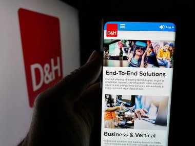 Stuttgart, Almanya - 05-15-2025: BT dağıtım şirketi DH Distributing Co 'nun web sayfası ile akıllı telefon sahibi kişi logonun önünde ekranda. Telefon ekranının merkezine odaklan.