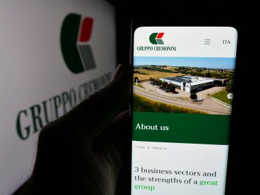 Stuttgart, Almanya - 05-15-2025: Et işleme şirketi Cremonini S.P.A. 'nın web sayfası ile akıllı telefonu olan kişi logonun önünde ekranda. Telefon ekranının merkezine odaklan.
