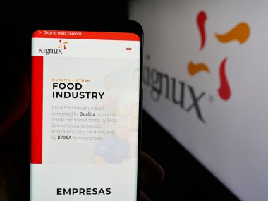 Stuttgart, Almanya - 05-15-2025: Meksika şirketi Xignux S.A. de C.V. 'nin web sayfası olan cep telefonu logonun önünde ekranda. Telefon ekranının merkezine odaklan.