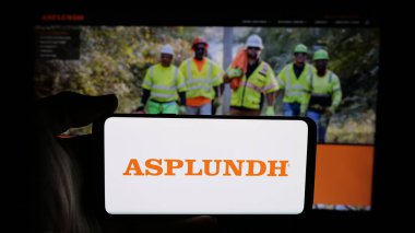 Stuttgart, Almanya - 05-15-2025: Web sayfası önünde ekranda Asplundh Tree Expert LLLC logosunun bulunduğu cep telefonu sahibi kişi. Telefon ekranına odaklan.