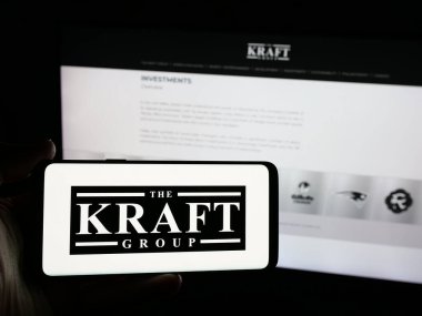 Stuttgart, Almanya - 05-15-2025: ABD 'li holding şirketi Kraft Group LLC' nin logosuna sahip kişi web sitesinin önünde ekranda. Telefon ekranına odaklan.