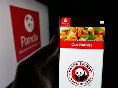 Stuttgart, Almanya - 05-15-2025: ABD 'li Panda Restaurant Group Inc.' in web sayfası ile akıllı telefon sahibi kişi logonun önünde ekranda. Telefon ekranının merkezine odaklan.